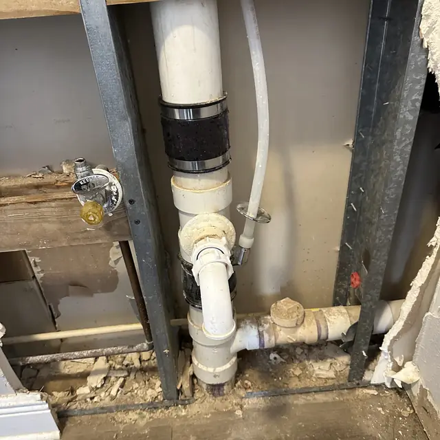 PVC drain stack and fittings set between steel studs in an opened wall